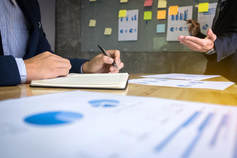 Profissionais analisando gráficos e documentos durante um curso de ISO 9001.